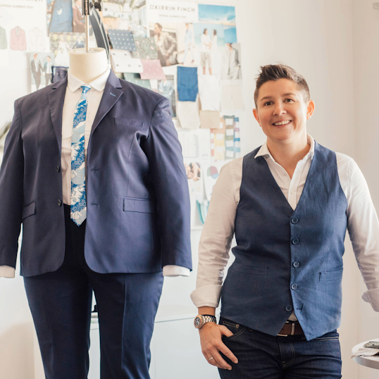 Co-Founder of Kirrin Finch standing next to a mannequin in a suit.
