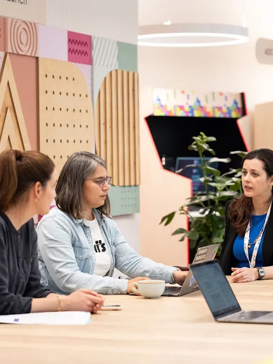 Cinq personnes sont assises autour d'une table et discutent. Elles se trouvent dans l'ADC.