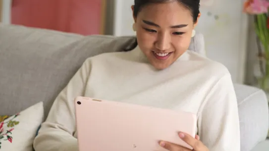 Seseorang tersenyum saat melihat sesuatu di perangkat Pixel Tablet.